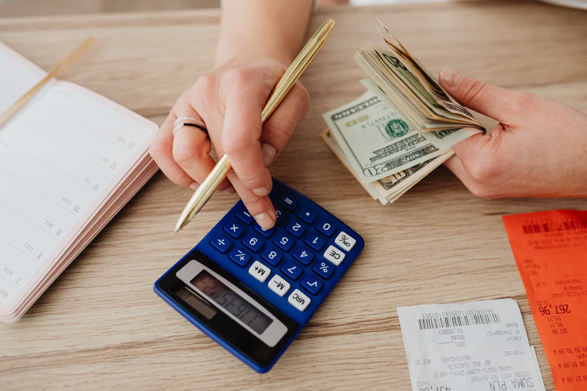 A notebook and calculator on a desk beside home fitness equipment