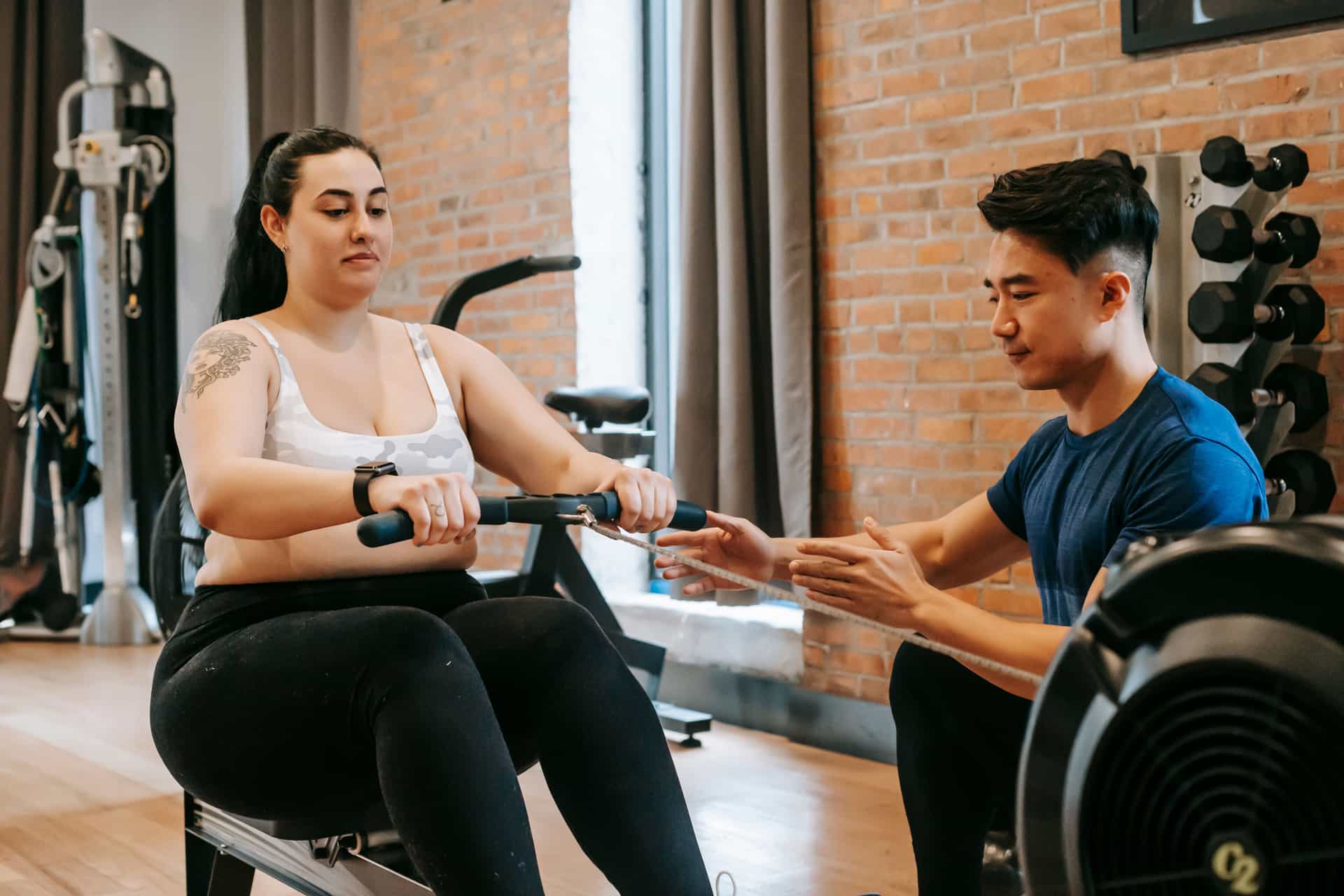 A person rowing on an indoor rower showing the leg drive position