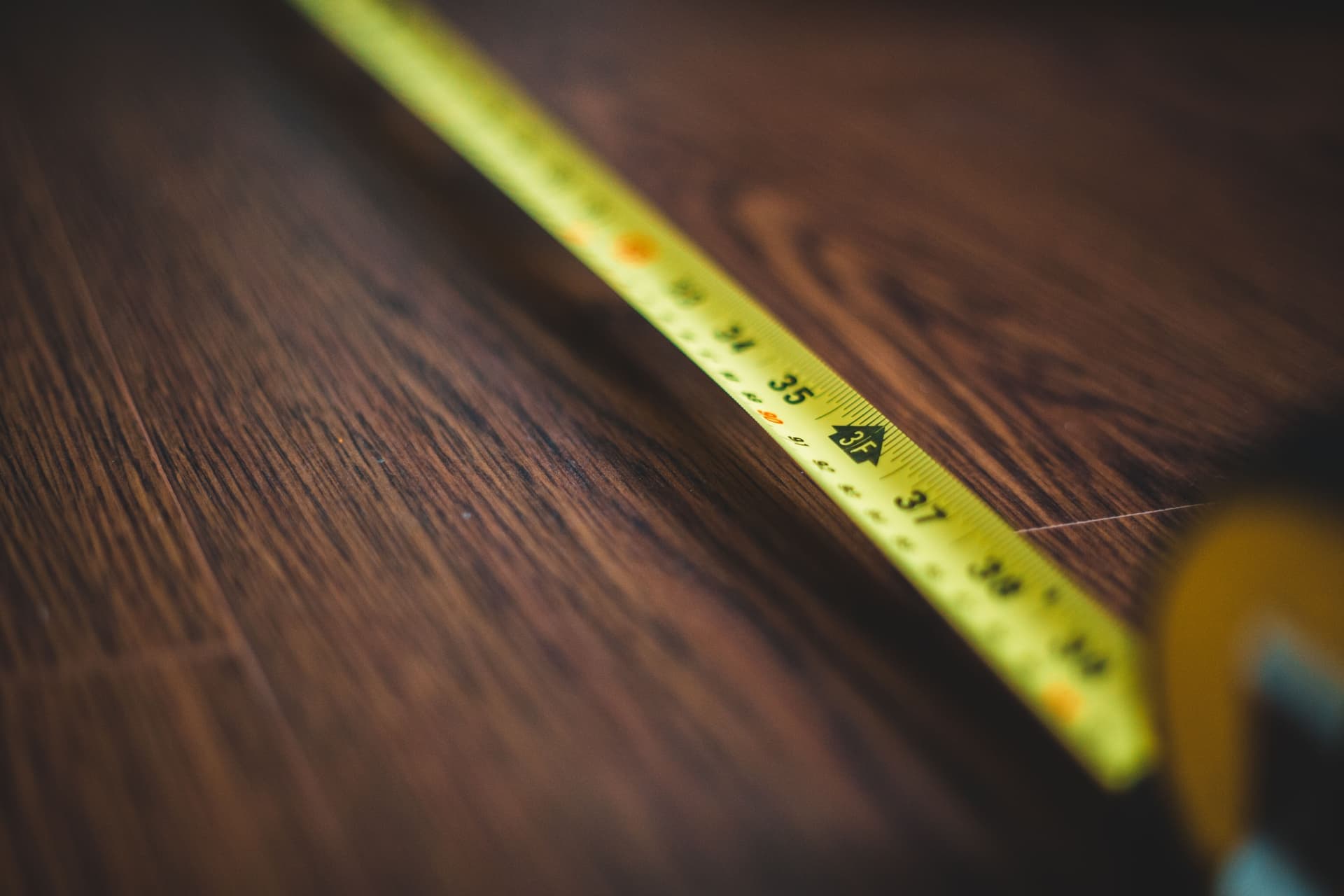 An empty room with a tape measure and floor space for exercise equipment