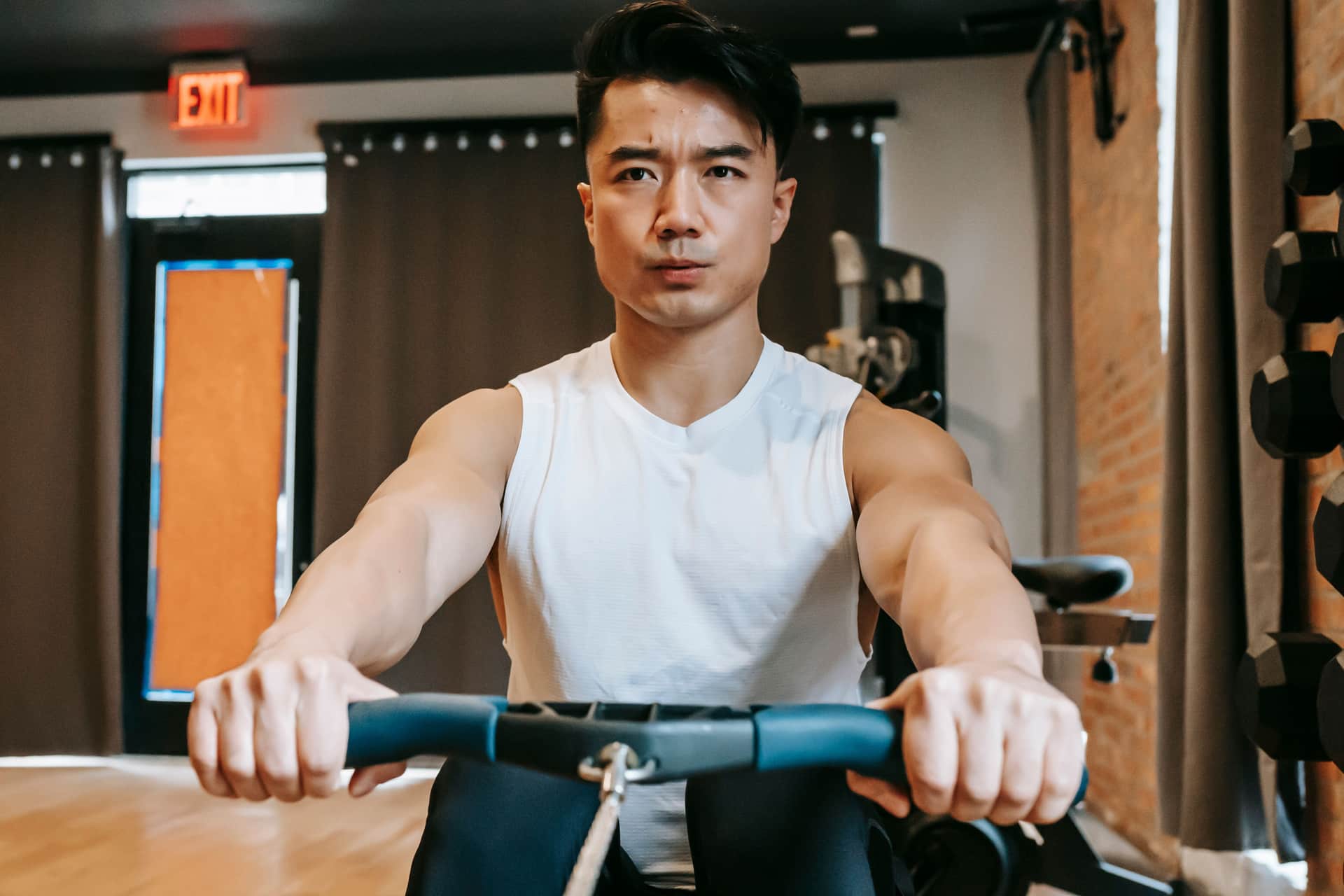 Close view of hands gripping an indoor rowing machine handle